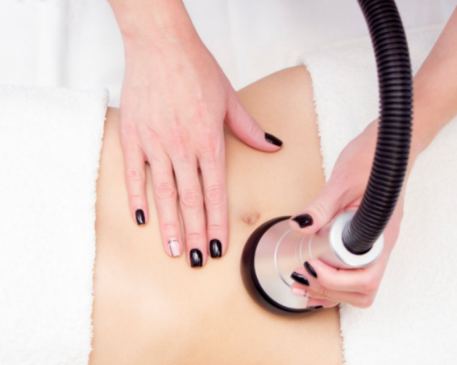 woman doing Ultrasonic Cavitation on her tummy fro weight loss/ slimming